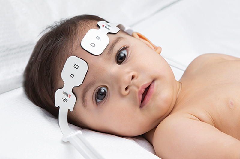 Crying infant in incubator in neonatal intensive care unit.